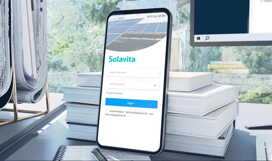 Die Solavita Cloud Energiemanagement-Plattform auf einem großen Bildschirm zeigt eine detaillierte Anlagenübersicht mit verschiedenen Solarenergie-Anlagendaten einschließlich Standort, Leistung und Systemstatusanzeigen. Im Vordergrund ist ein Smartphone mit dem Solavita Cloud Anmeldebildschirm zu sehen, was die geräteübergreifende Zugänglichkeit der Plattform demonstriert. Aufgenommen in einem modernen Arbeitsbereich mit sichtbarem Grün im Außenbereich.